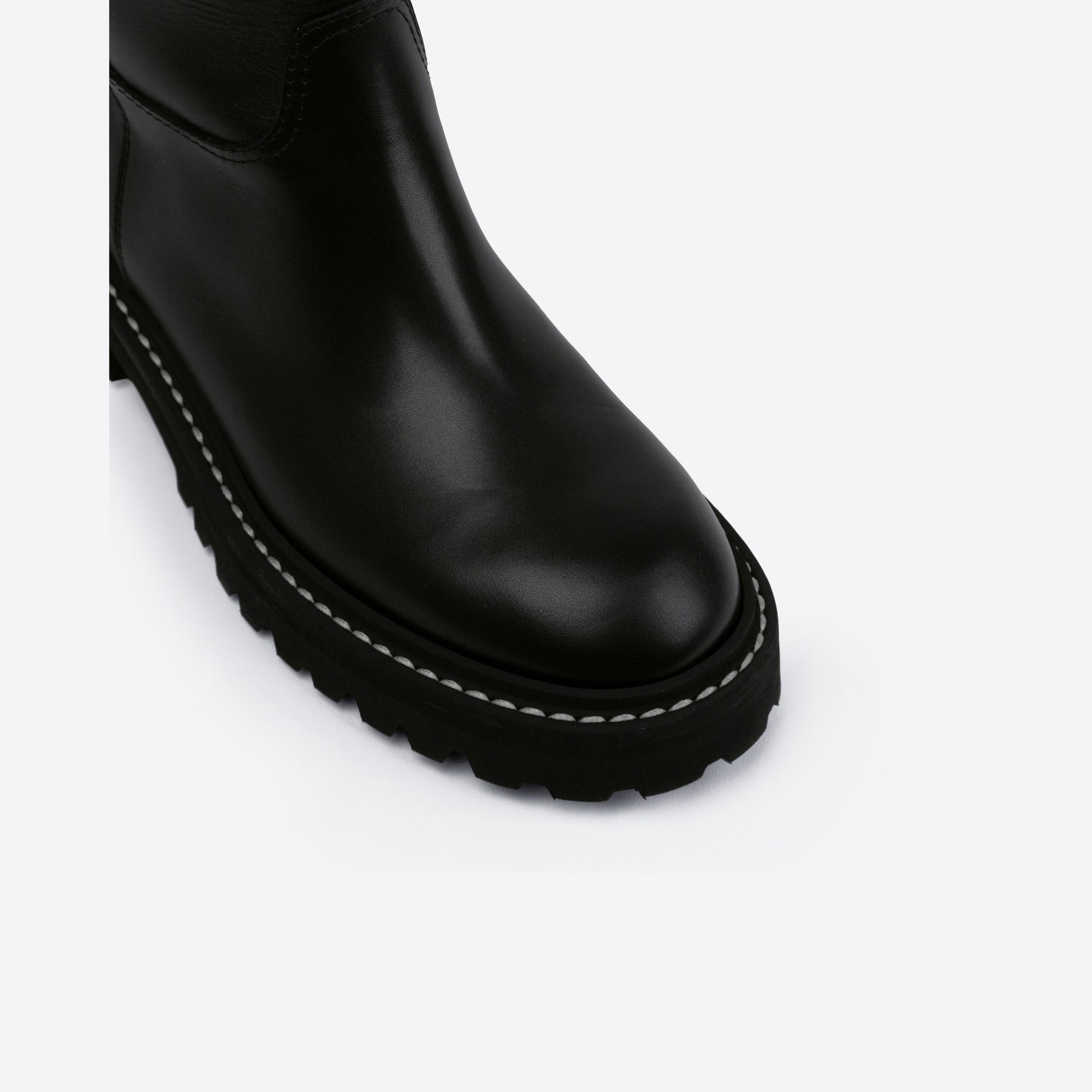 Close-up of a black leather boot with a rubber outsole on a white background