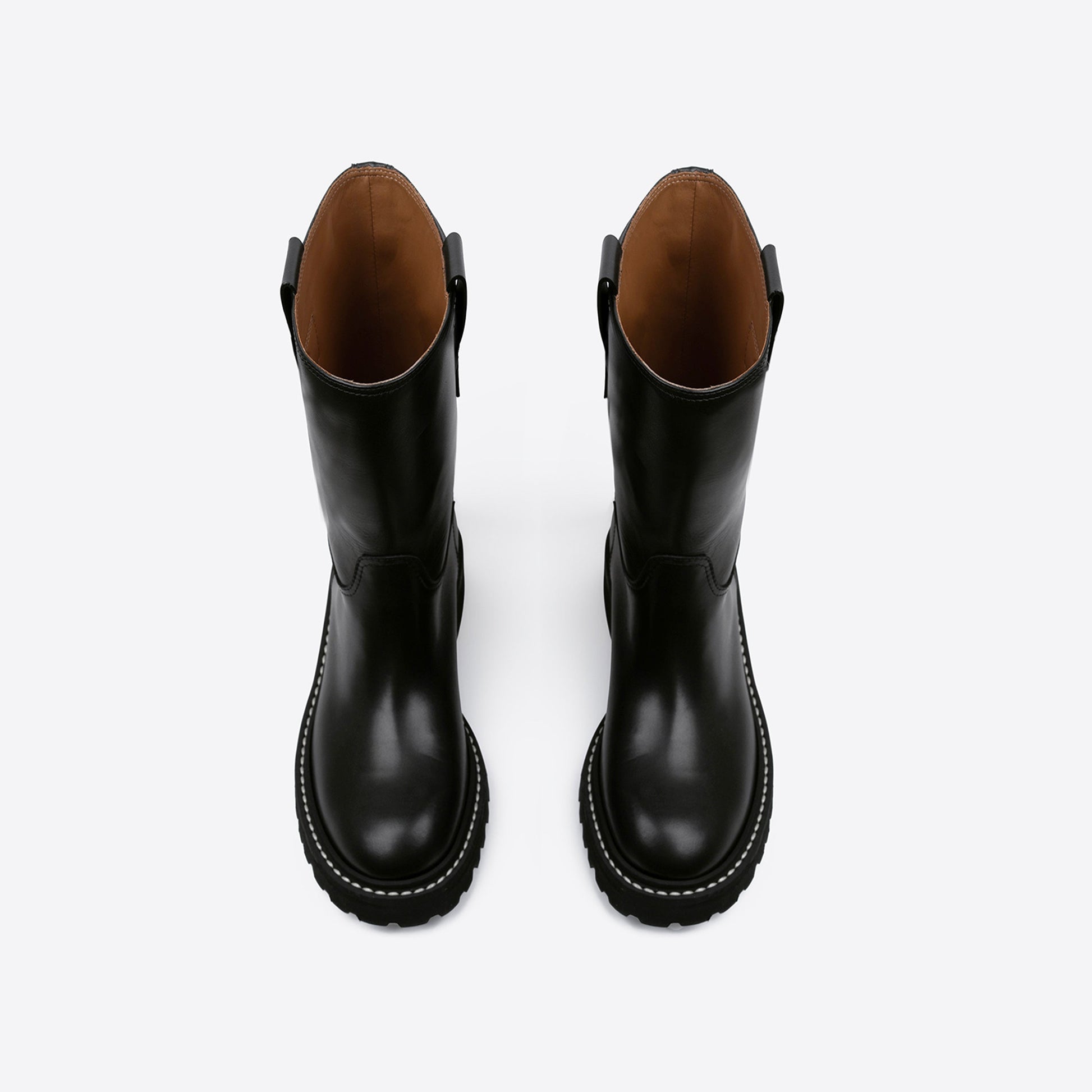 Top view of a pair of black leather boots with a rubber outsole on a white background
