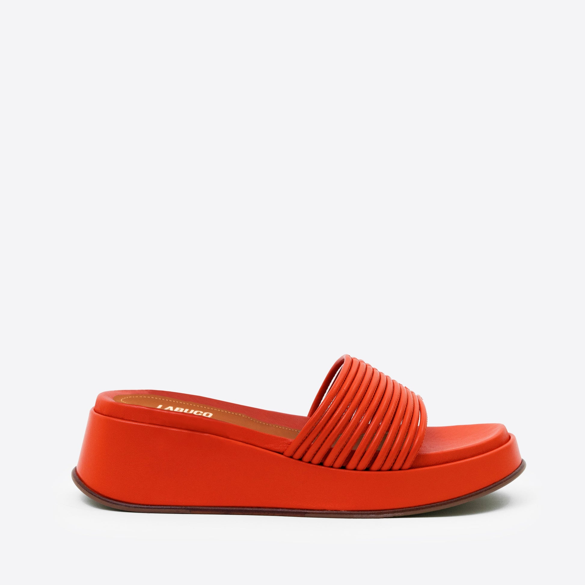 Caye Slide Tangerine in black product against studio photography