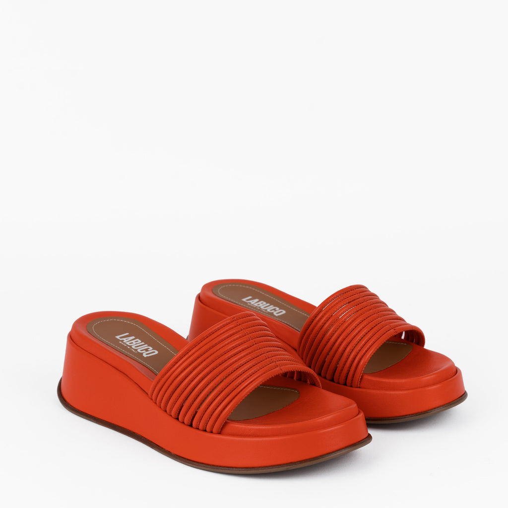 Caye Slide Tangerine in black product against studio photography