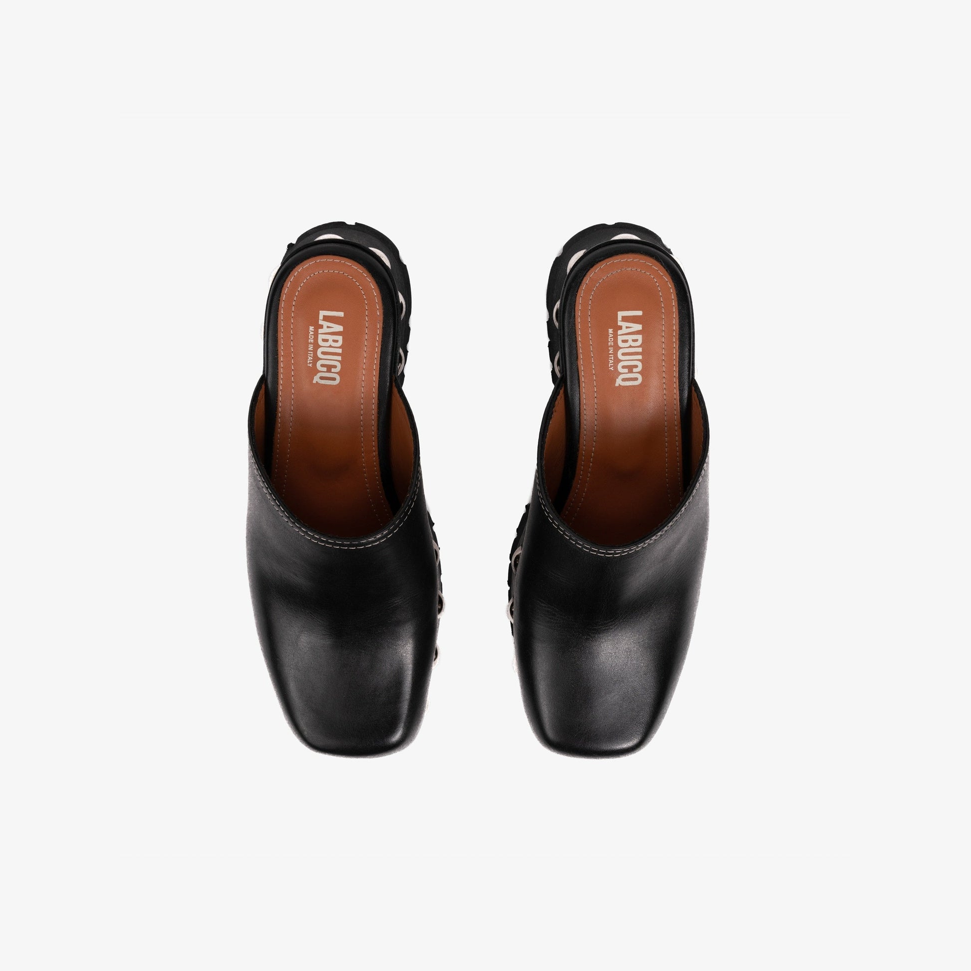 Top-view shot of a black clog with studs, visible Labucq branding, and a black treaded rubber outsole on a white background