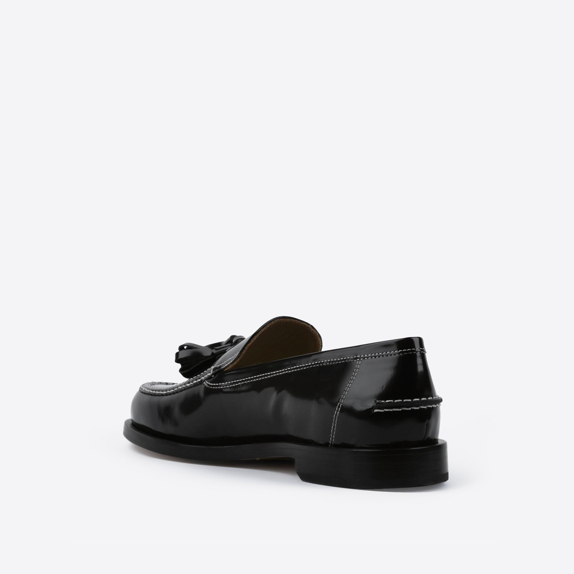 Black loafer with white stitching on a white background