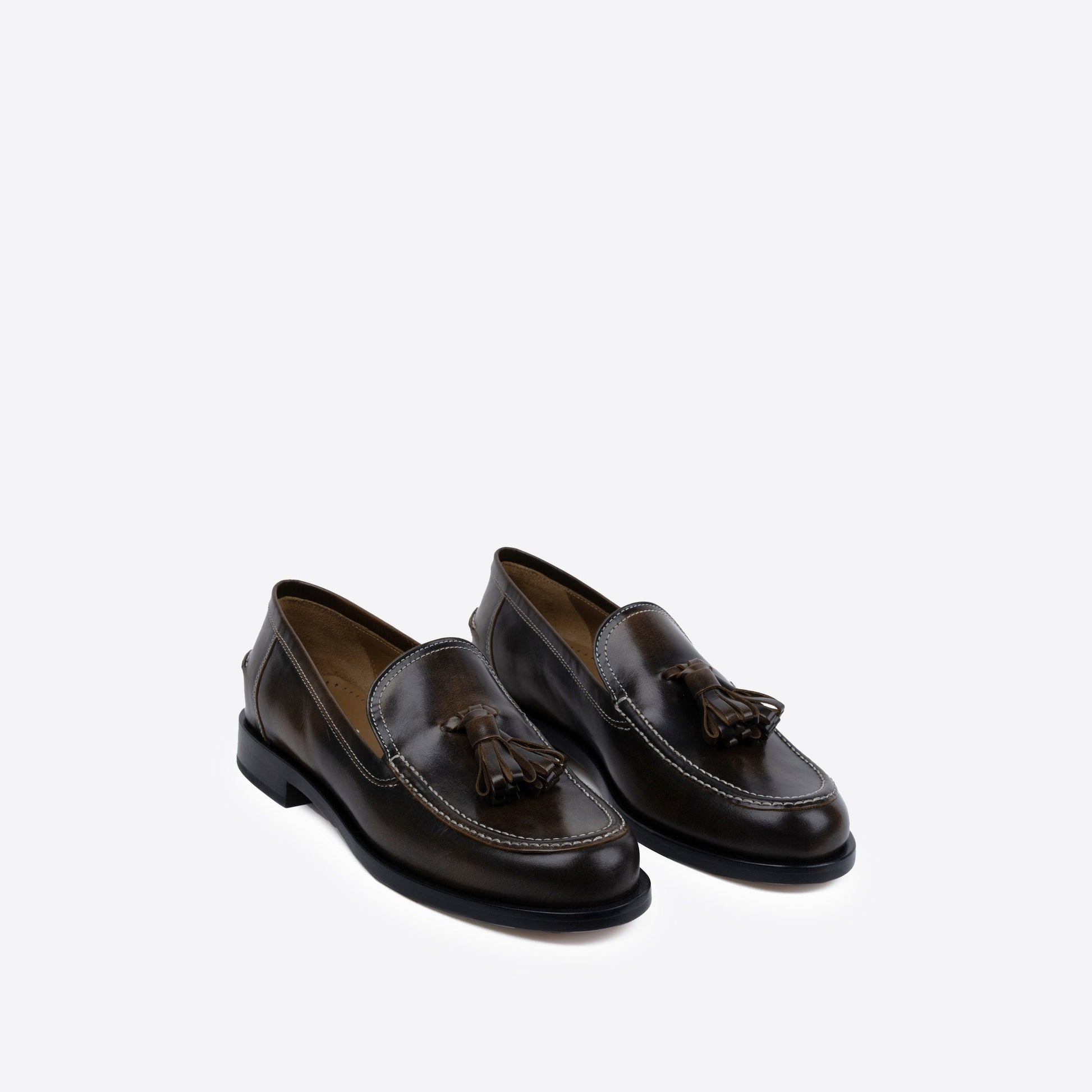 Pair of brown loafers with tassels on a white background