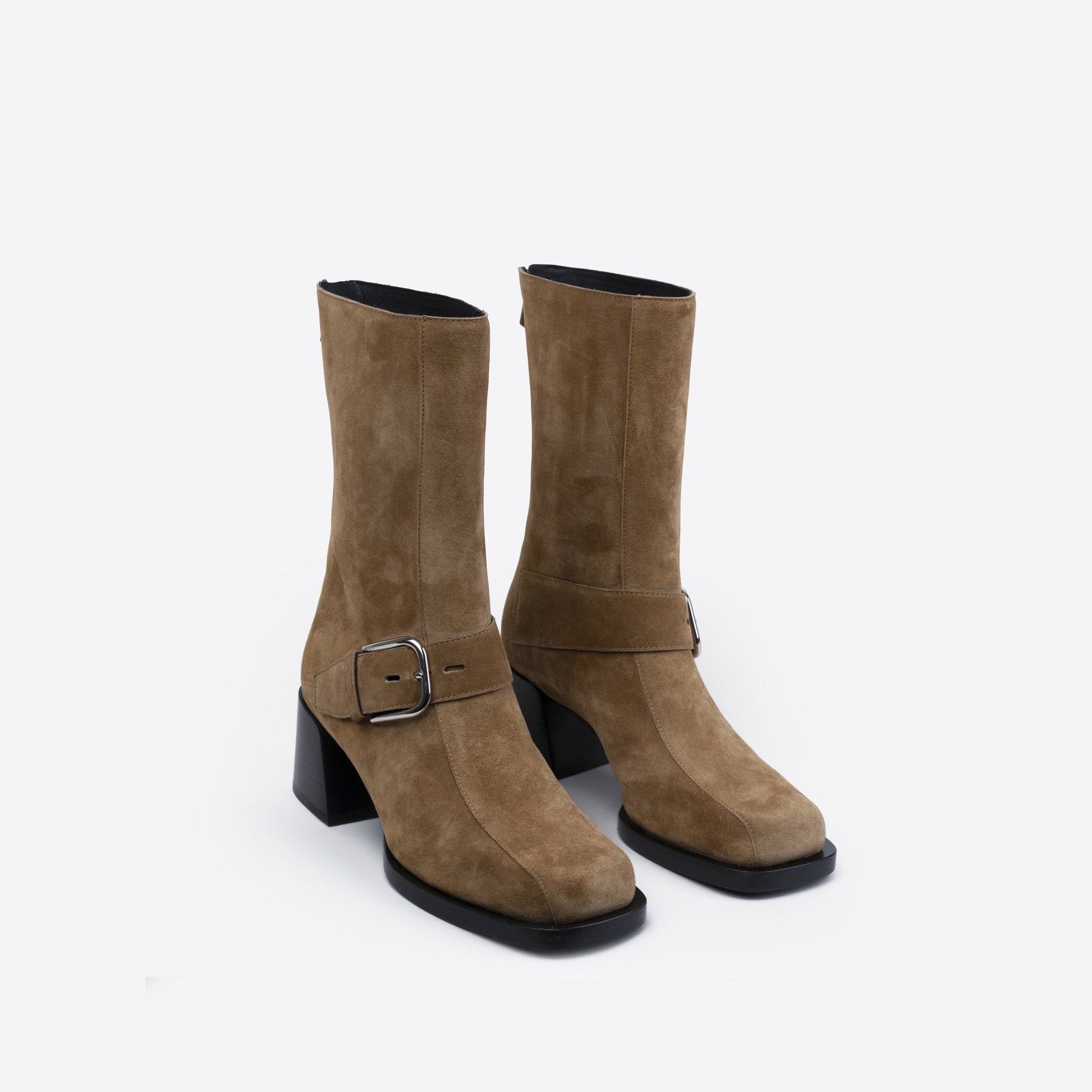 Pair of brown suede boots with a buckle on a white background