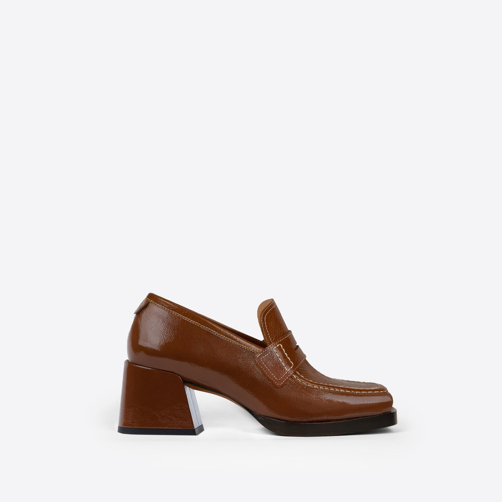 Brown loafer with a 2-inch block heel and black sole on a white background