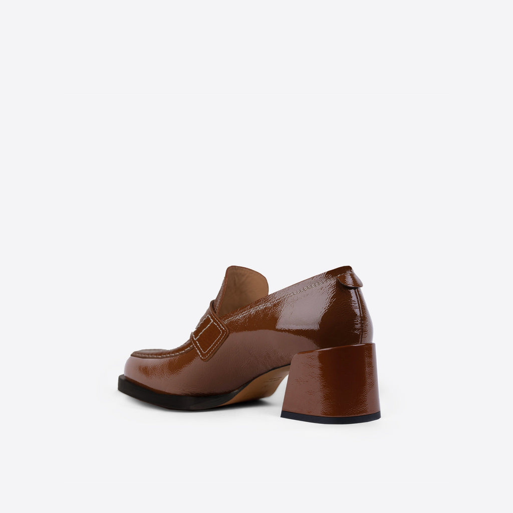 Brown loafer with a 2-inch block heel and black sole on a white background