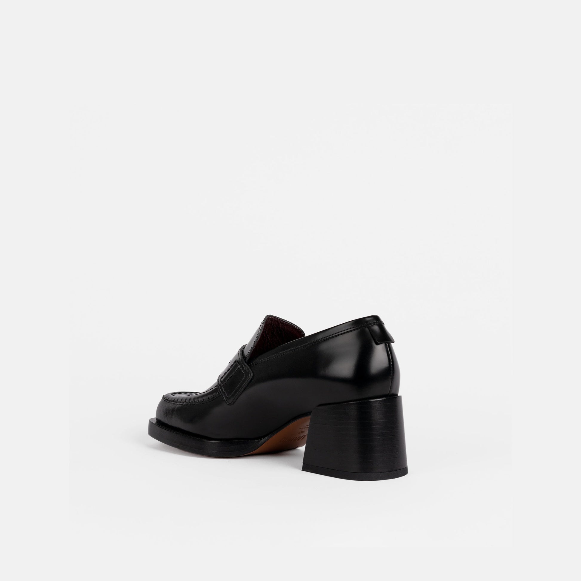 Black loafer with a 2-inch block heel on a white background