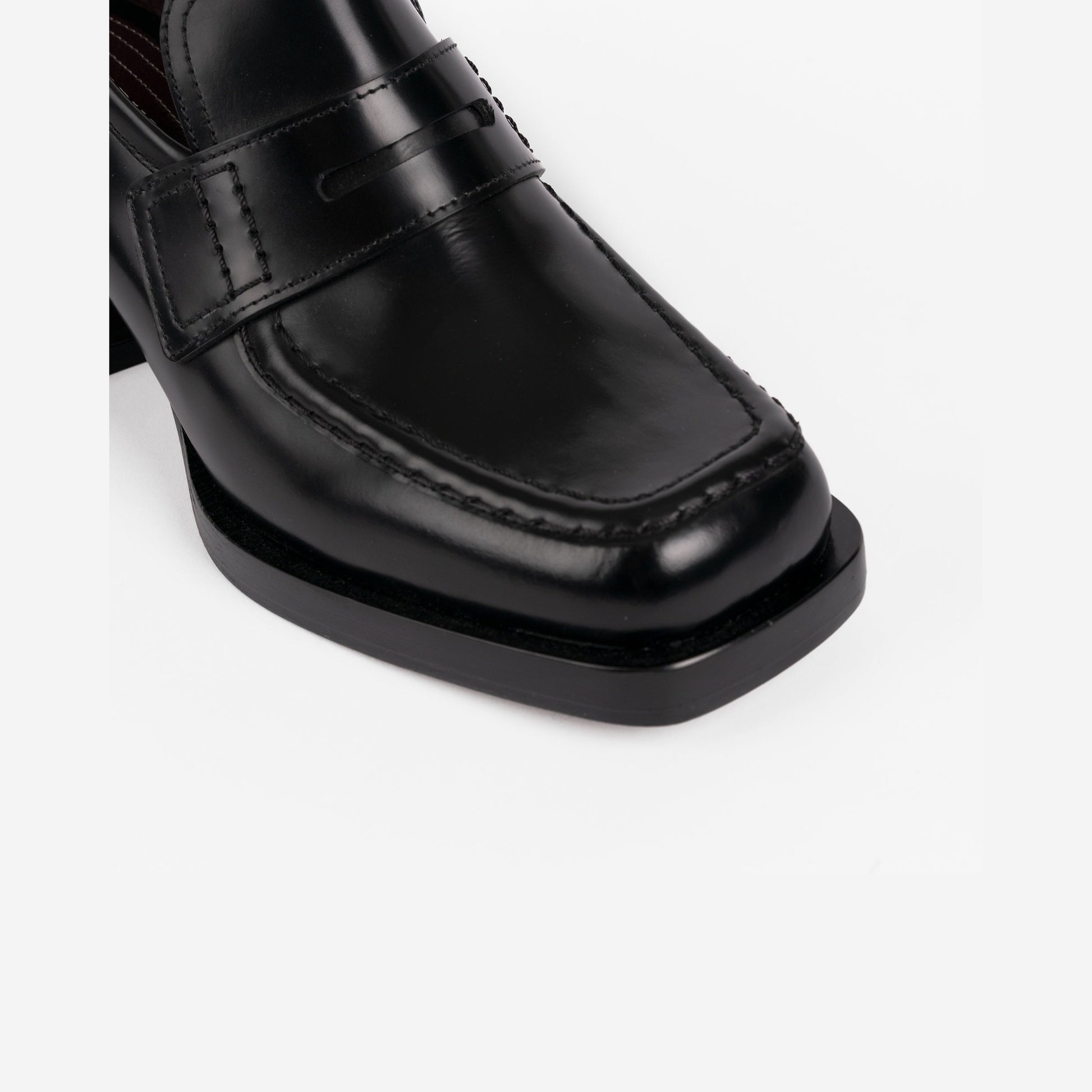 Close-up of black loafer on a white background