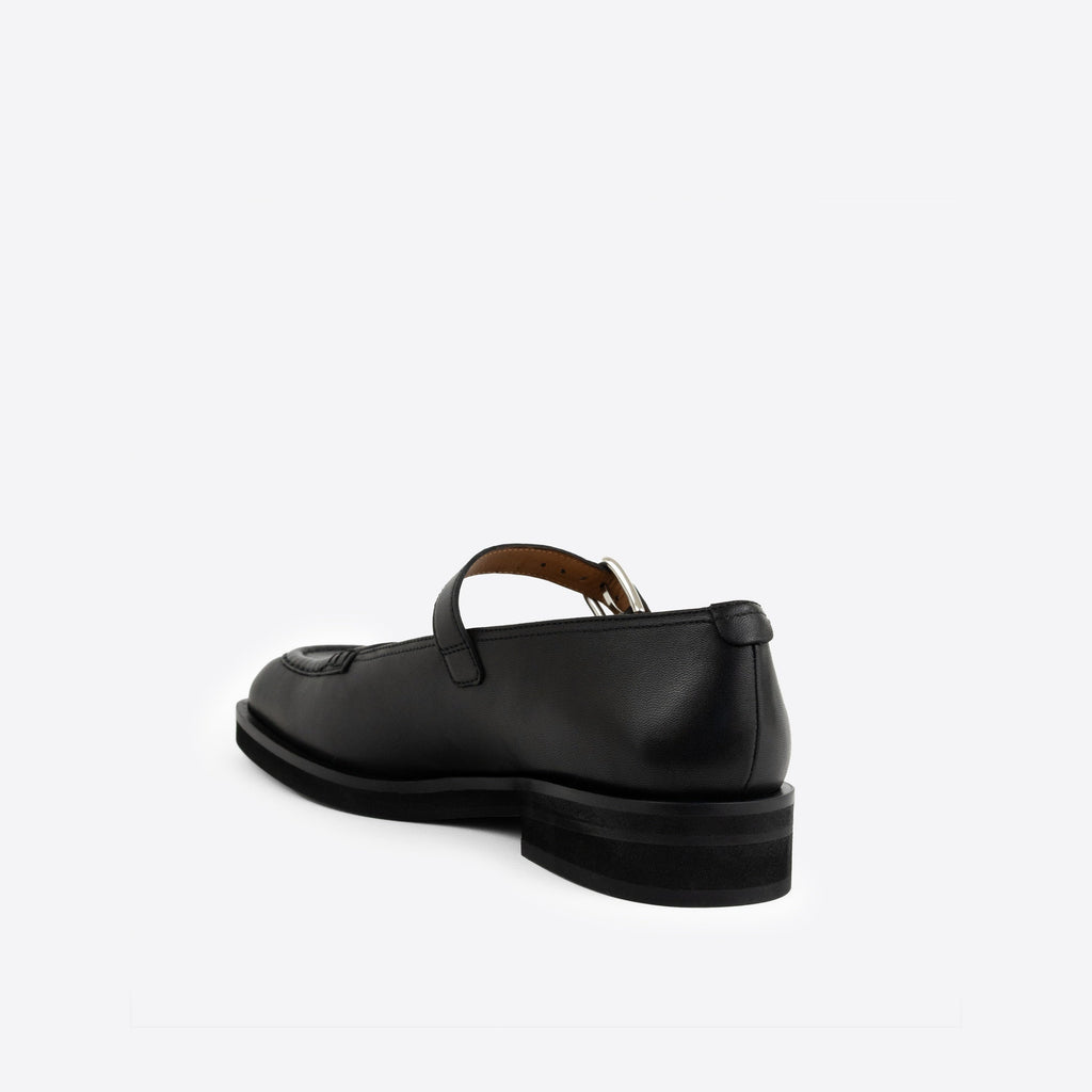 Black Maryjanes with a black sole and a buckle on a white background
