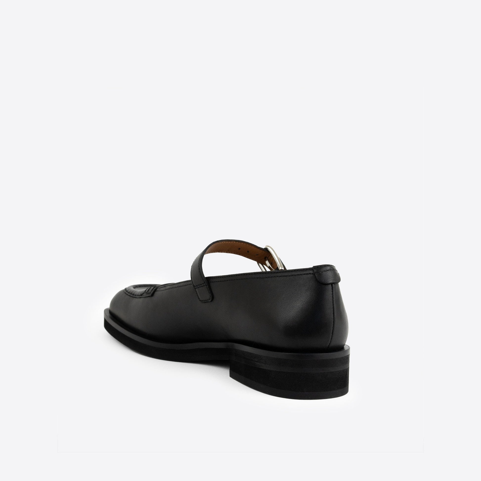 Black Maryjanes with a black sole and a buckle on a white background