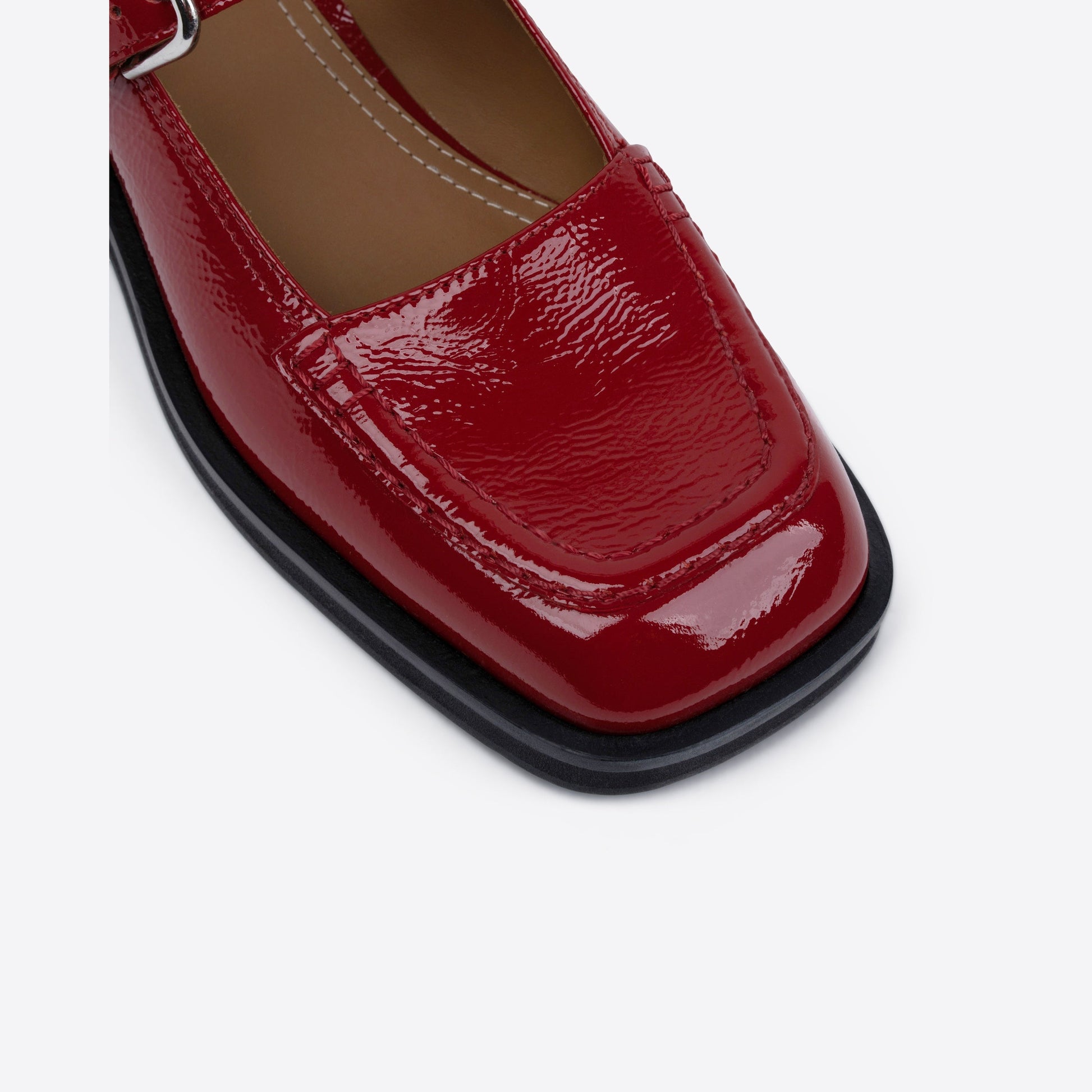 Close-up shot of a red patent leather shoe on a white background