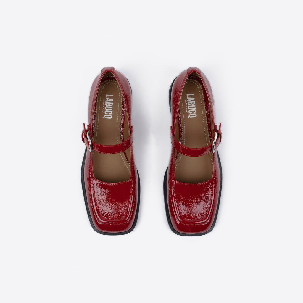 Red shoes with a square toe and black sole on a white background