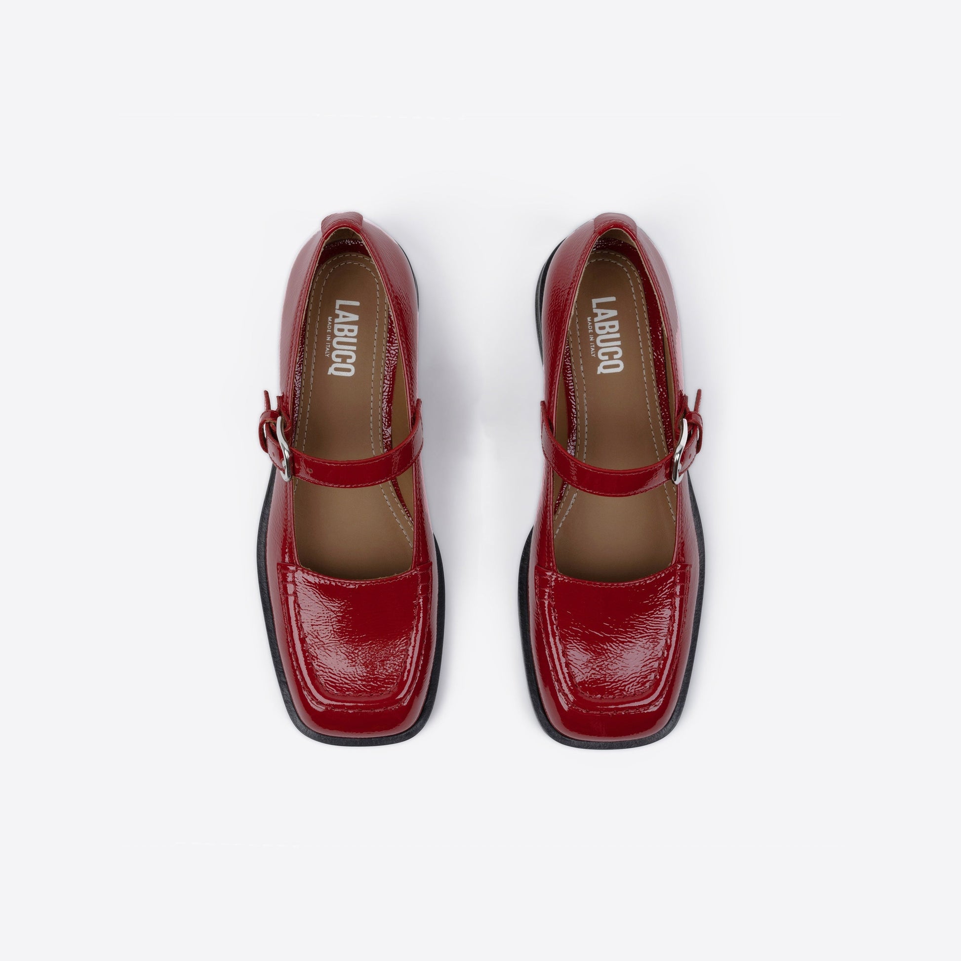 Red shoes with a square toe and black sole on a white background