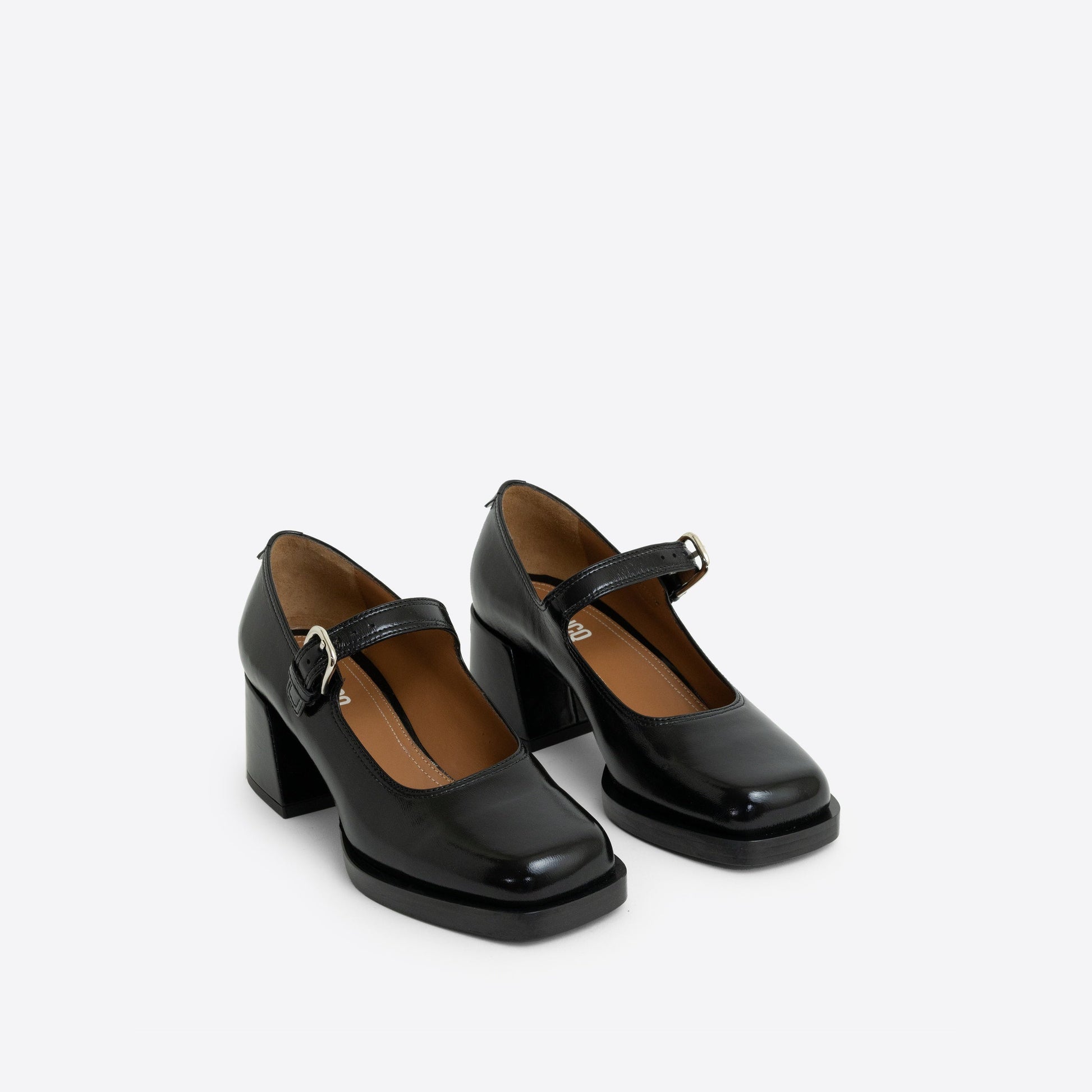 Pair of black patent leather Maryjanes with a buckle, a 2-inch heel, and a black sole on a white background