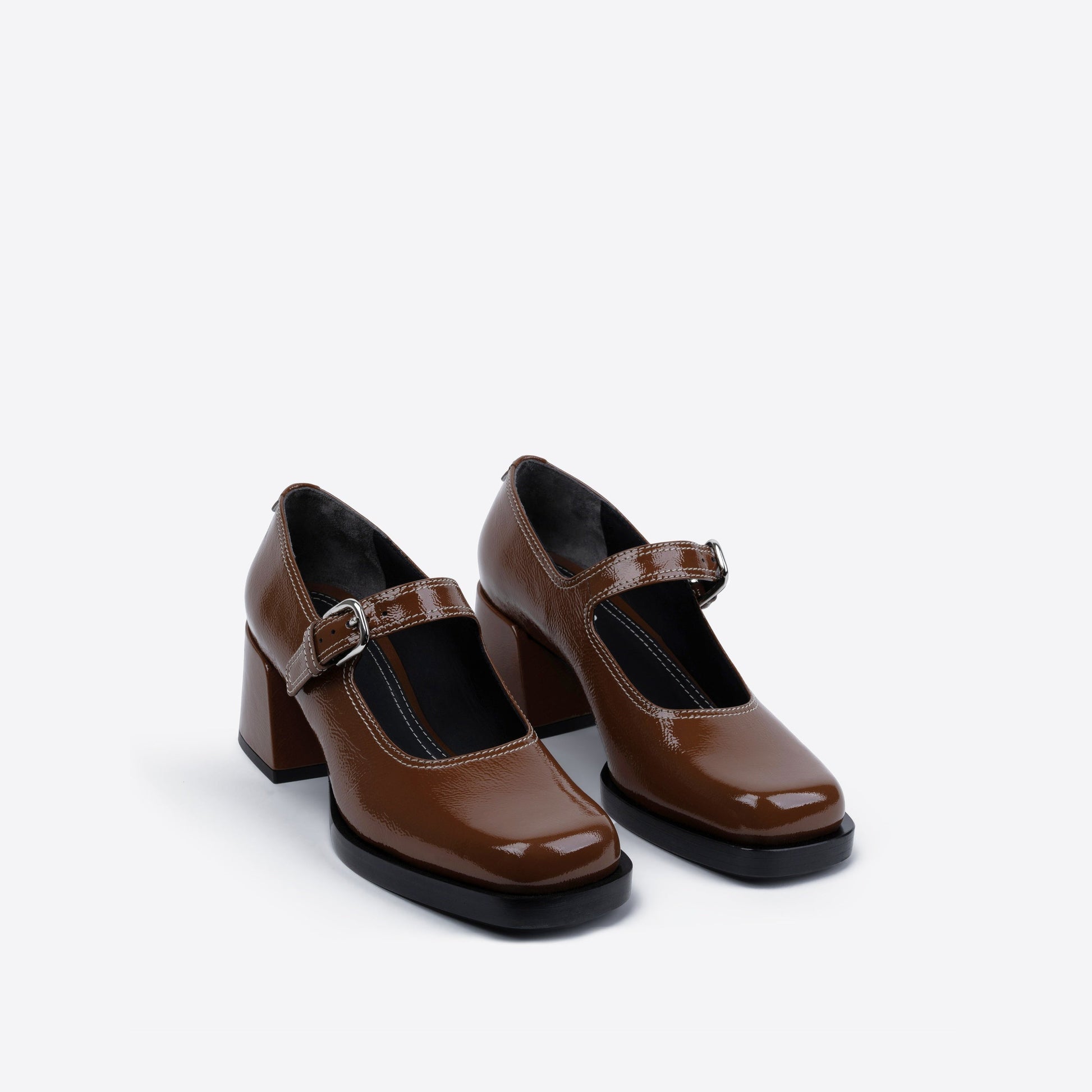 Pair of brown high-heeled shoes with a strap on a white background