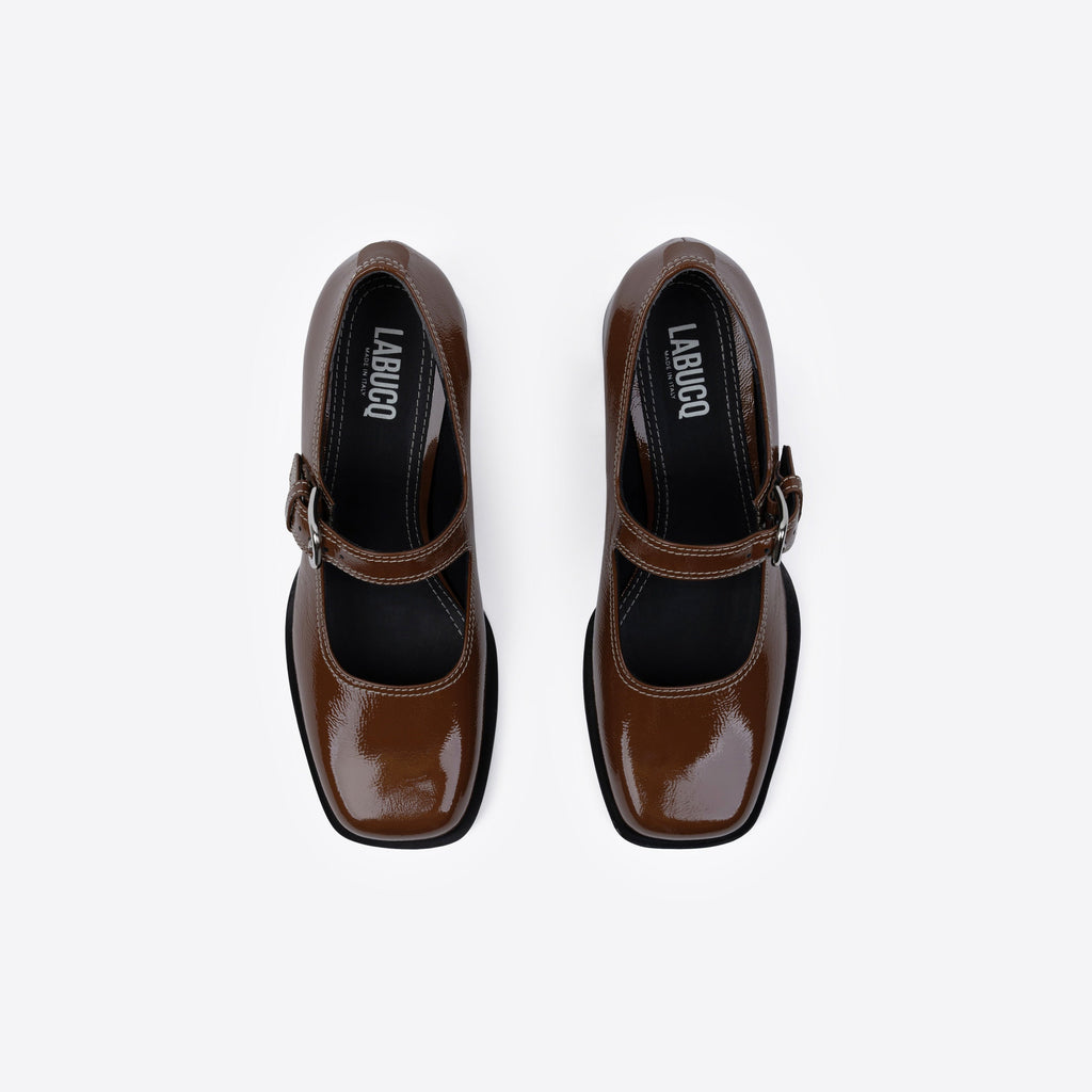 Brown patent leather shoes featuring Labucq branding and a buckle on a white background