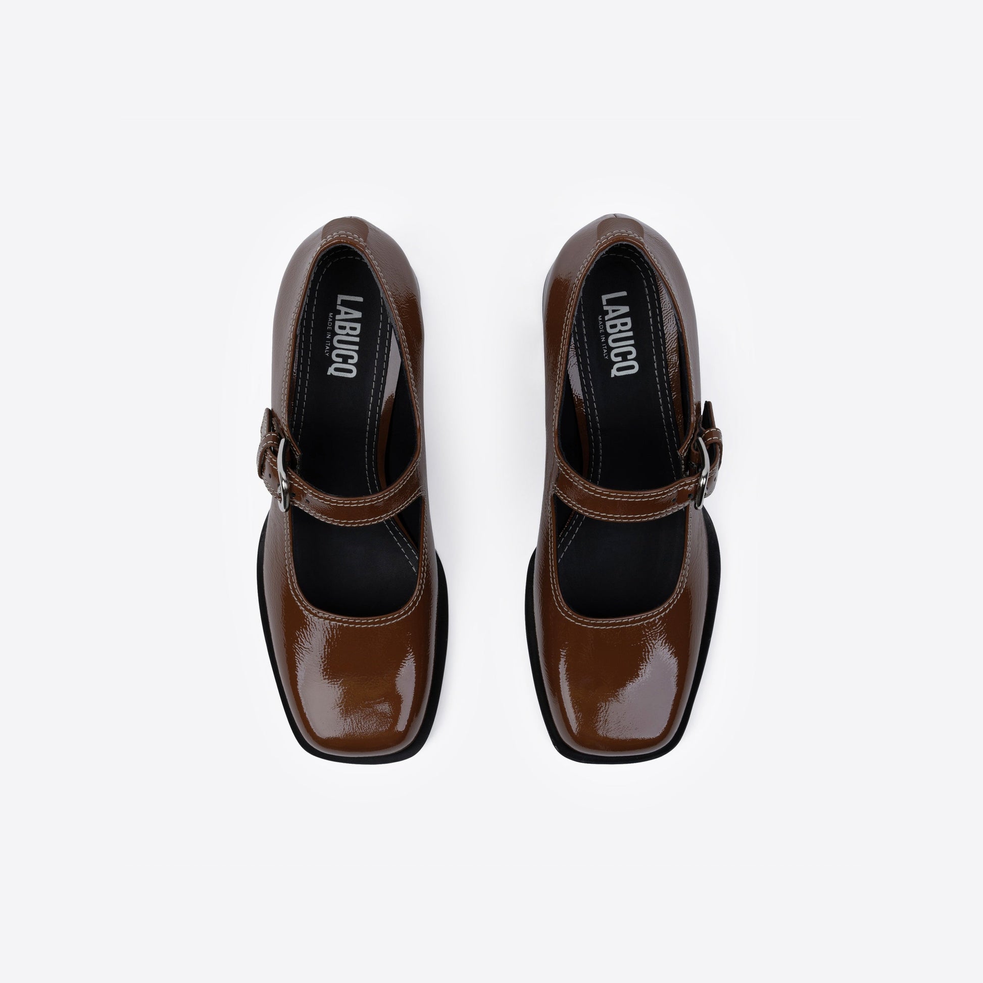 Brown patent leather shoes featuring Labucq branding and a buckle on a white background