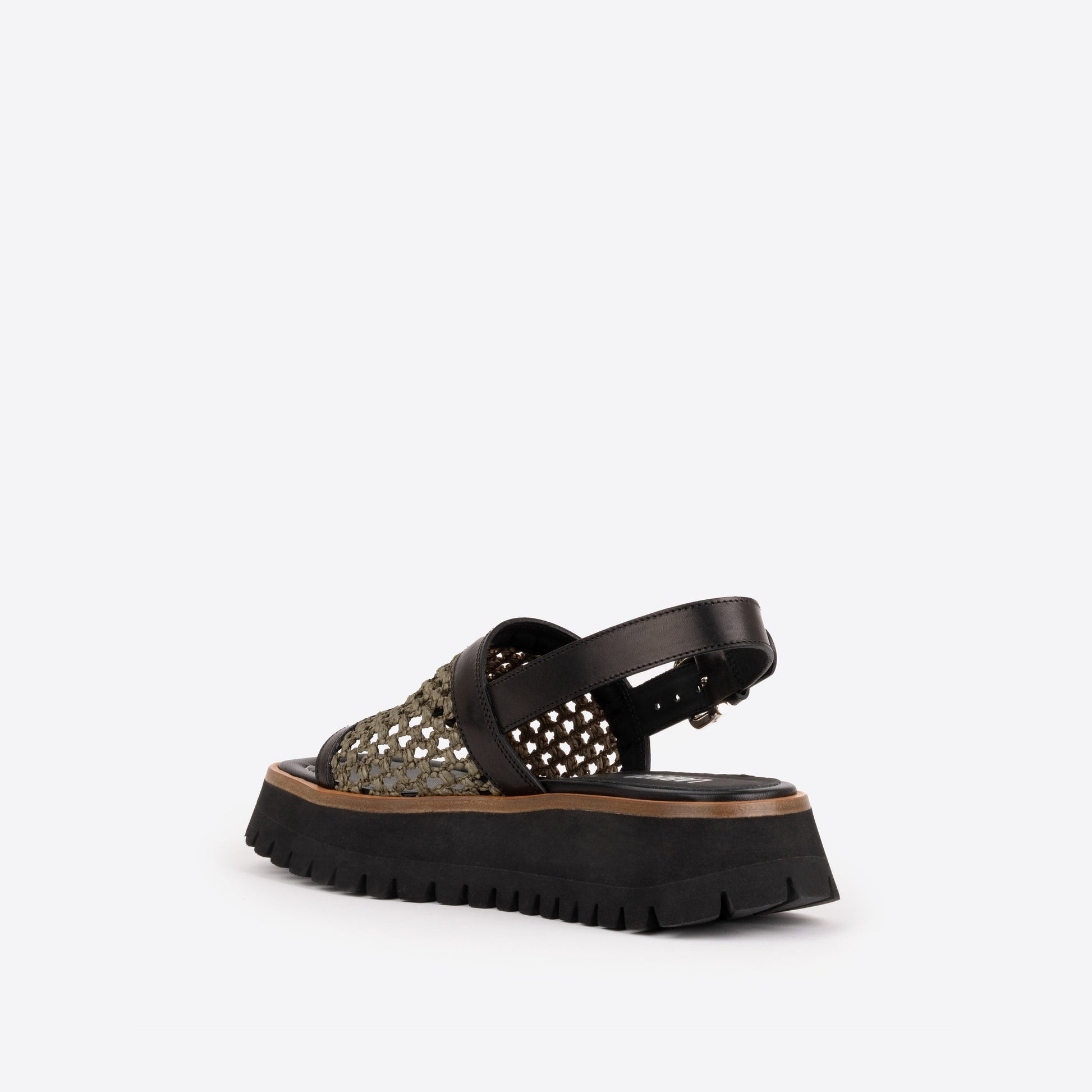 Black platform sandal with brown lining and an olive woven raffia strap on a white background