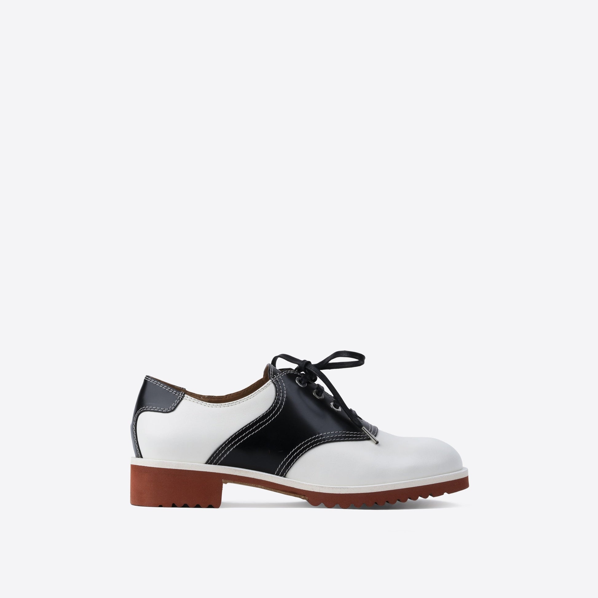 White and black leather shoe with black laces and a brown sole on a white background