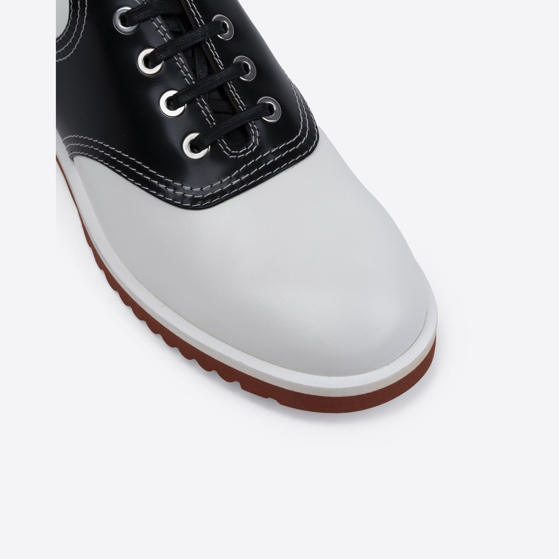 Black and white shoe with a brown sole on a light gray background