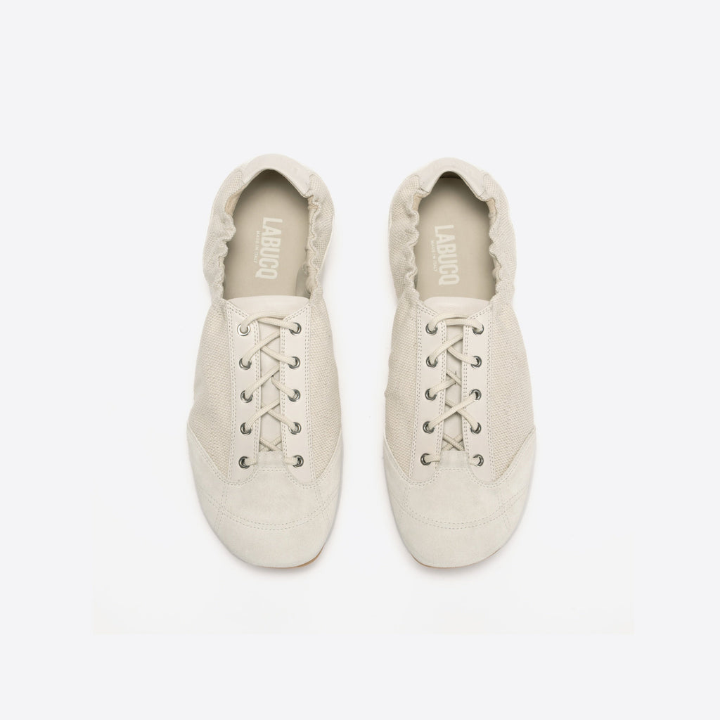 Pair of white shoes with lace-up design on a light gray background