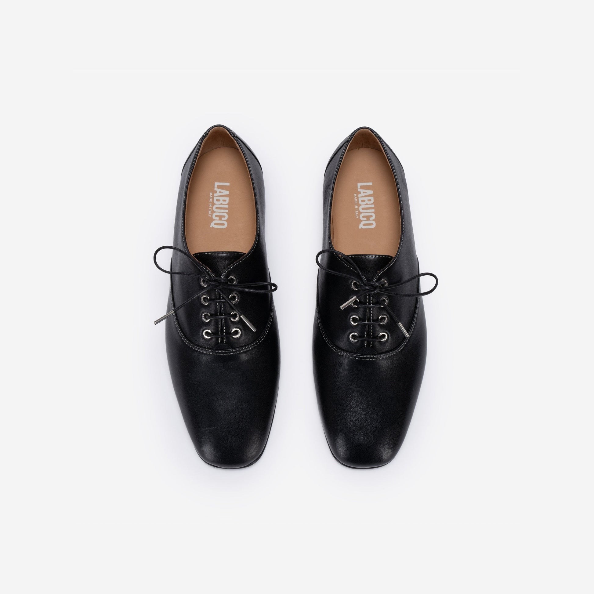 Pair of black leather shoes with 'Labucq' branding on a white background